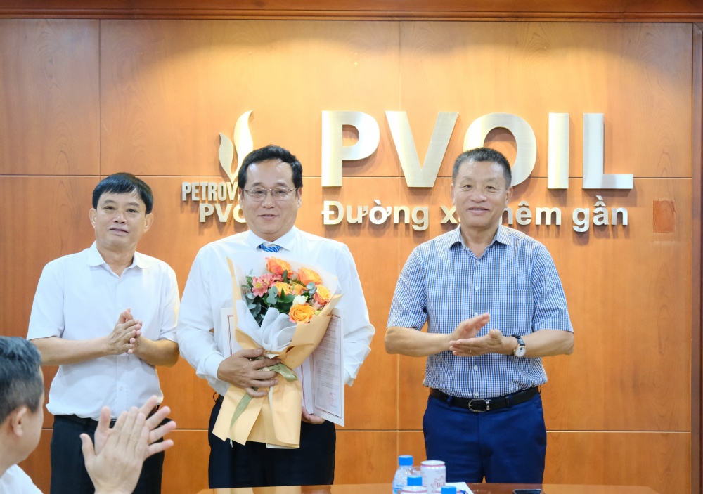 Ông Đoàn Văn Nhuộm – Tổng Giám đốc PVOIL (bên phải) và ông Nguyễn Mậu Dũng – Thành viên HĐQT PVOIL (bên trái) trao Quyết định và tặng hoa chúc mừng ông Phạm Đình Ngọc Minh giữ chức Giám đốc PVOIL Quảng Ngãi