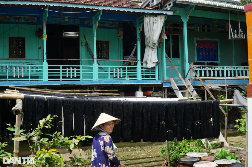Người phụ nữ phơi chỉ trước nhà sàn, cùng với khăn rằn, nhà sàn cũng là điều độc đáo ở cù Lao Long Khánh (Ảnh: Nguyễn Cường).