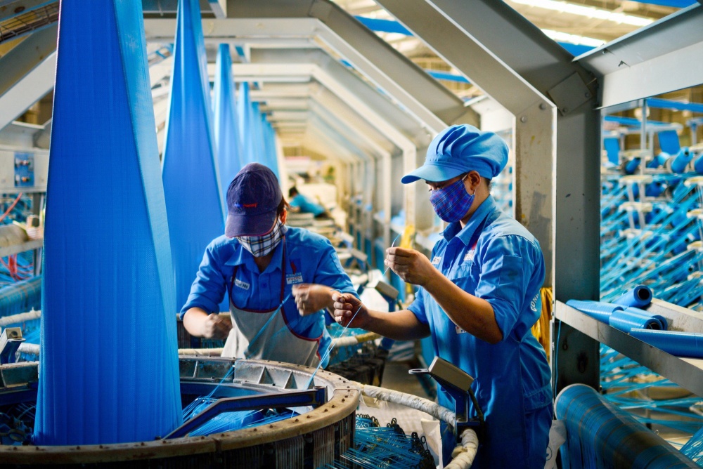 14-BNDH-AB-0001-03: Nữ công nhân dệt đang vận hành máy.