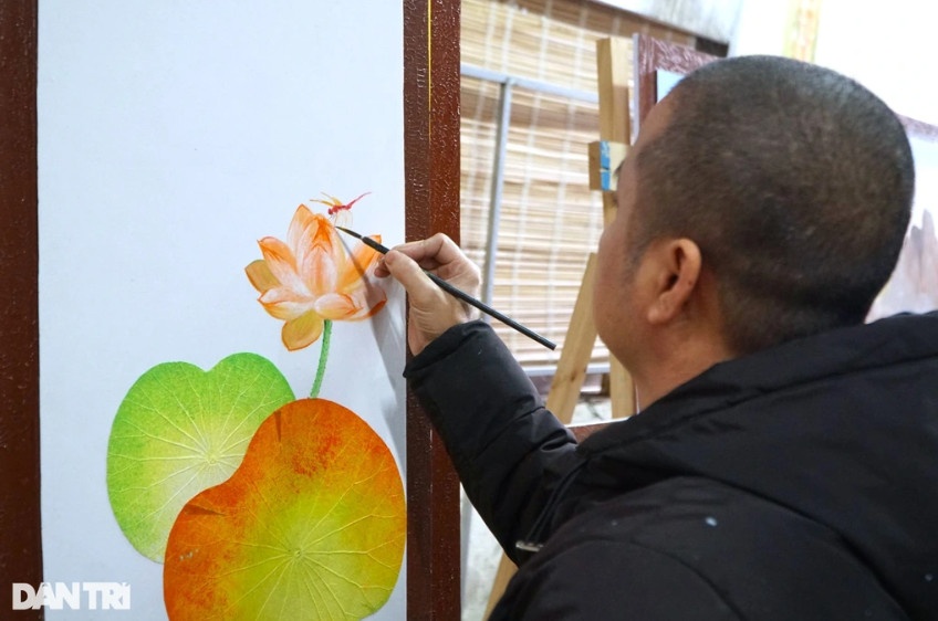 Anh Tuyển đang kết hợp vẽ tranh với lá sen (Ảnh: Thanh Tùng).