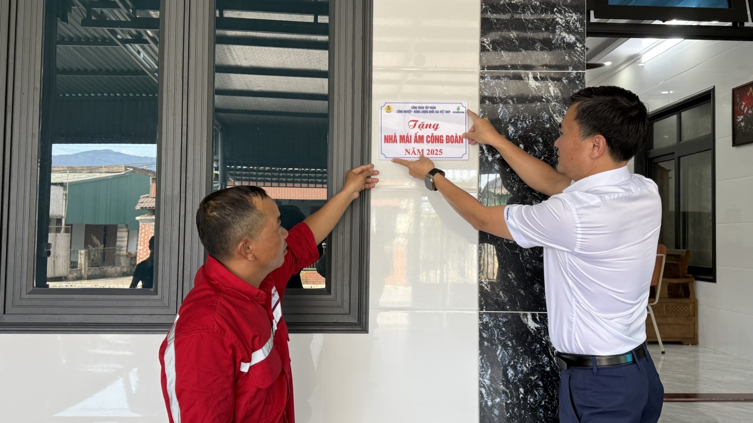 Đồng chí Vũ Anh Tuấn, Phó Chủ tịch Công đoàn Petrovietnam cùng gắn biển nhà Mái ấm cho gia đình anh Nguyễn Văn Thành