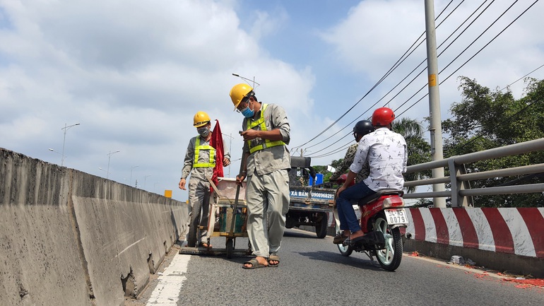 Kinh hãi với hàng trăm mảnh nhọn hoắt rải đầy trên cầu vượt ở TPHCM - 1